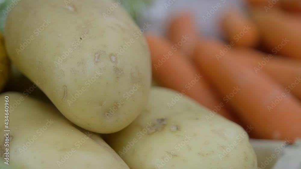 Colorful vegetables stand with onions, potatoes, and carrots Colorful vegetables stand with onions, potatoes, and carrots