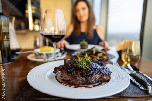 Obraz na płótnie Gourmet grilled ribeye steak dinner with red wine on a date with a woman. w salonie