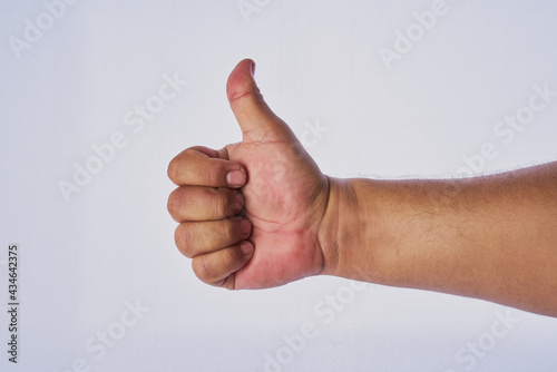 Mano de hombre adulto latino haciendo un gesto en un fondo blanco © GERMAN
