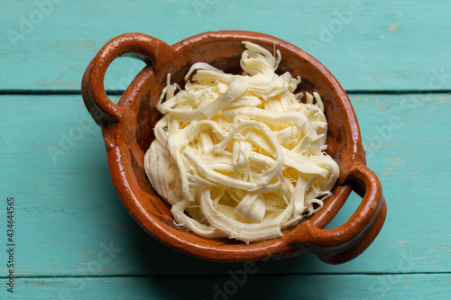 Canvas Print Shredded Oaxaca cheese also called quesillo on turquoise background