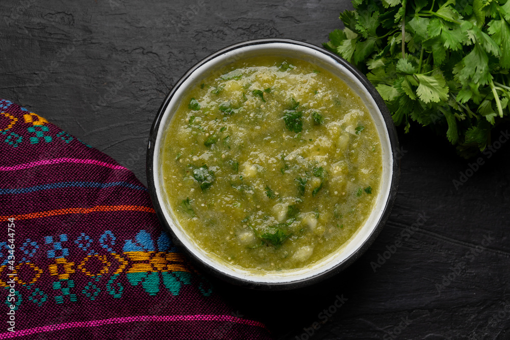 Mexican piquant green sauce with cilantro and onion on dark background Mexican piquant green sauce with cilantro and onion on dark background