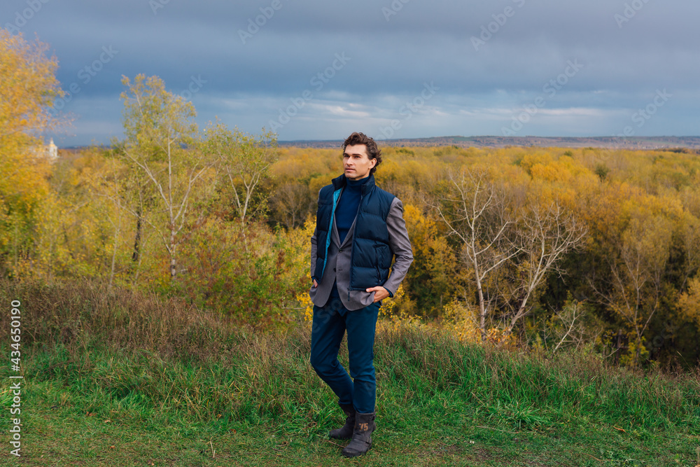 Tall handsome man outdoor in autumn forest on the hill Tall handsome man outdoor in autumn forest on the hill