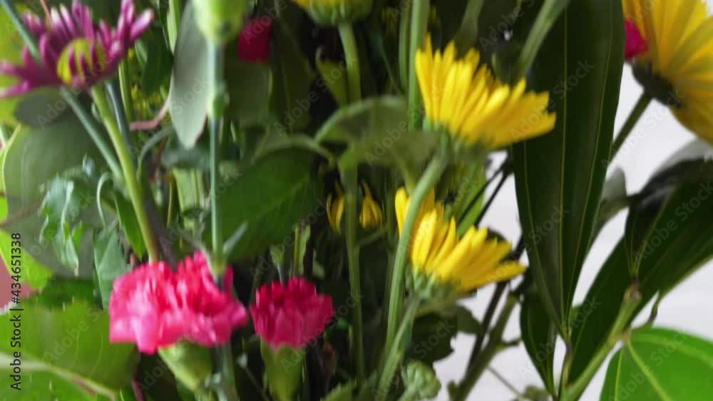 Beautiful Bouquet of Flowers in Rectangular Glass Vase Sitting in Water Close Up with Candles Lit on Fire, Smooth Pan Up, Store Bought Yellow, Green, Purple, and Orange Beautiful Bouquet of Flowers in Rectangular Glass Vase Sitting in Water Close Up with Candles Lit on Fire, Smooth Pan Up, Store Bought Yellow, Green, Purple, and Orange