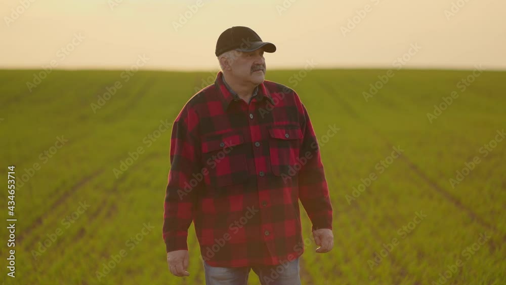 Portrait of a tractor farmer walking through a field at sunset after a slow-motion shoot Portrait of a tractor farmer walking through a field at sunset after a slow-motion shoot