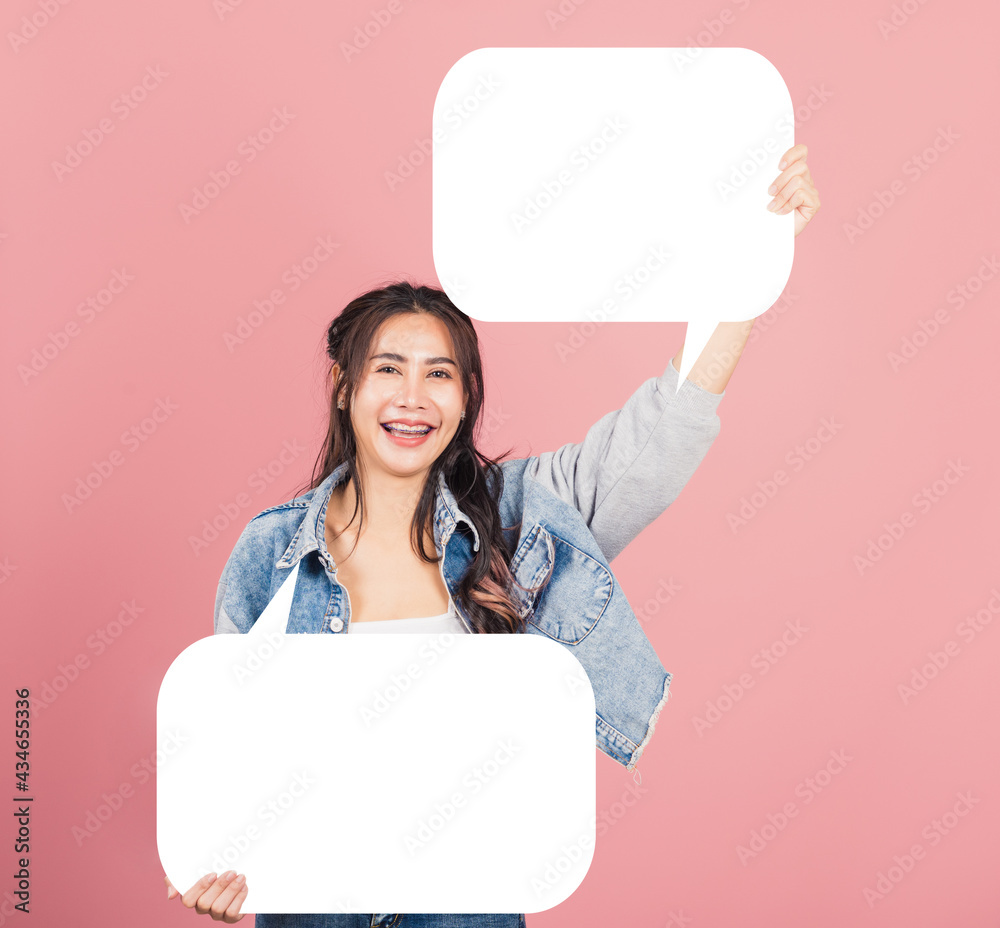 Happy Asian beautiful young woman smiling excited wear denims holding empty speech bubble sign, Portrait female posing show up for your idea looking at camera, studio shot isolated on pink background Happy Asian beautiful young woman smiling excited wear denims holding empty speech bubble sign, Portrait female posing show up for your idea looking at camera, studio shot isolated on pink background