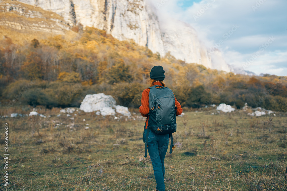 woman in autumn in the forest in nature in the blue sky mountains landscape