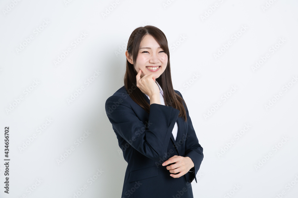 指を頬にあてて笑っているビジネスウーマン