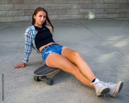 Young Woman Posing with Her Skateboard in an Urban Setting