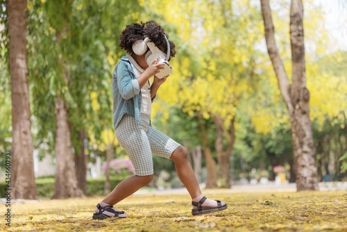 Cool millennial child exploring space with virtual reality glasses at outdoor