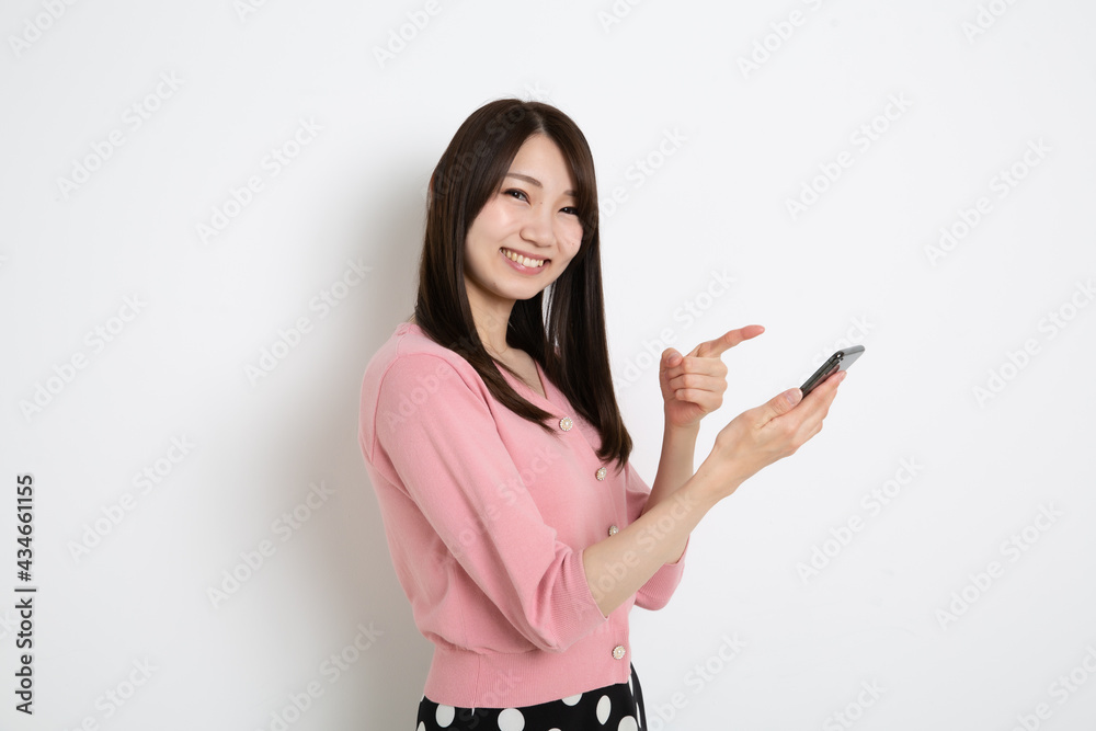 スマートフォンで検索をしている若い女性 スマートフォンで検索をしている若い女性
