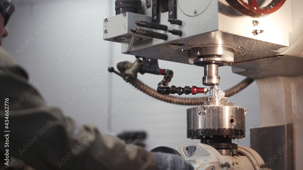 A metal workpiece is machined by an electric machine. Cutting metal modern processing technology. Coolant and lubrication. Produces metal detail in factory. Machine tools for metal working. A metal workpiece is machined by an electric machine. Cutting metal modern processing technology. Coolant and lubrication. Produces metal detail in factory. Machine tools for metal working.