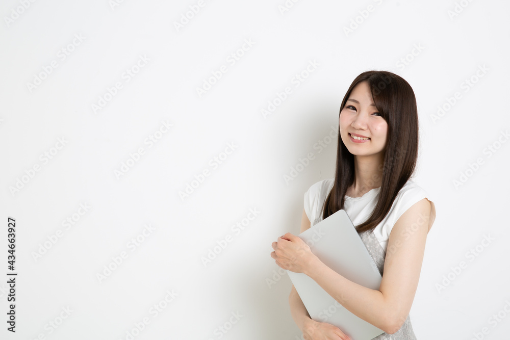 パソコンを抱えている笑顔の若い女性