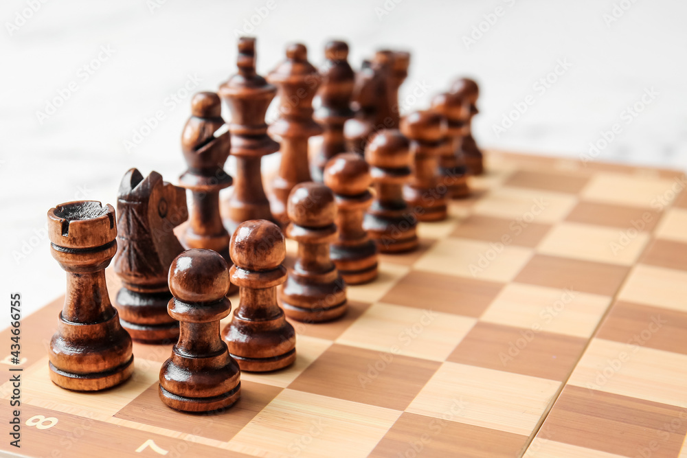 Chess pieces with game board on light background Chess pieces with game board on light background