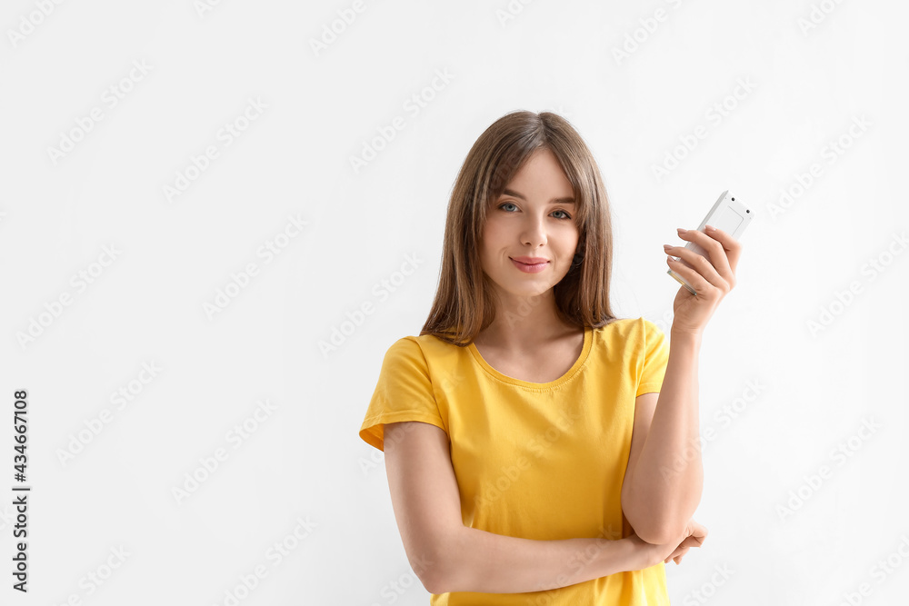 Young woman with air conditioner remote control on white background Young woman with air conditioner remote control on white background
