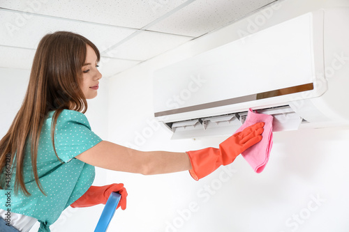 Young woman cleaning air co...