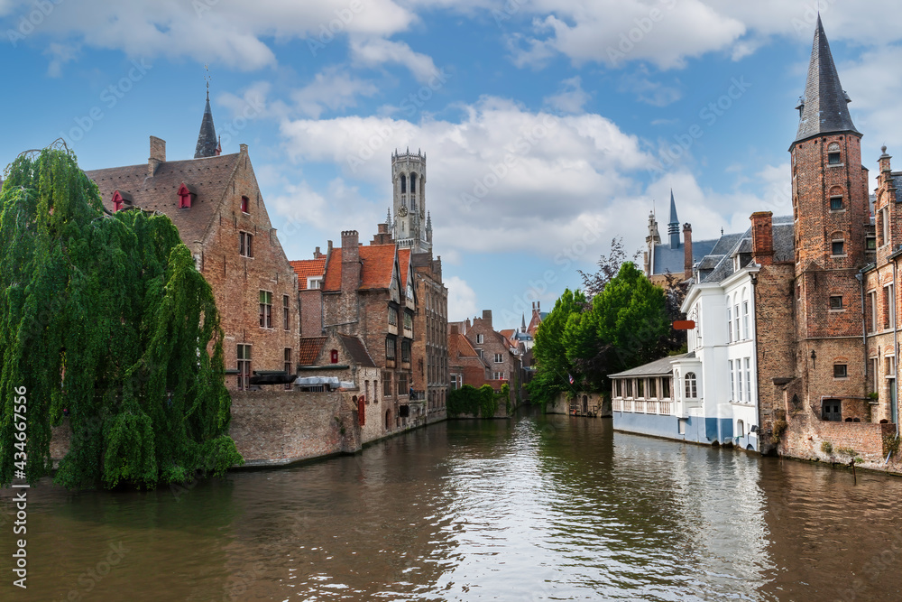 Obraz premium City view with historical houses, church, tower and famous canal in Bruges, Belgium.