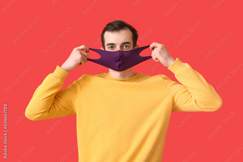 Young man wearing medical mask on color background Young man wearing medical mask on color background