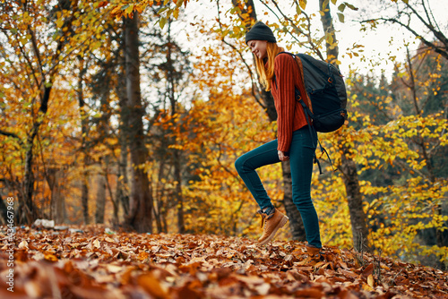 beautiful woman with a backpack in the park on nature landscape fallen leaves bottom view © SHOTPRIME STUDIO