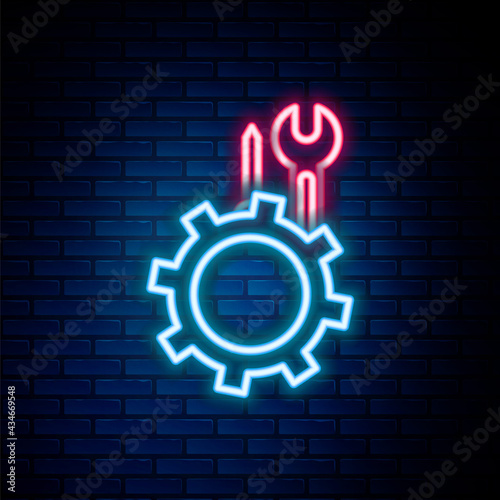 Glowing neon line Wrench and screwdriver in gear icon isolated on brick wall background. Adjusting, service, setting, maintenance, repair, fixing. Colorful outline concept. Vector