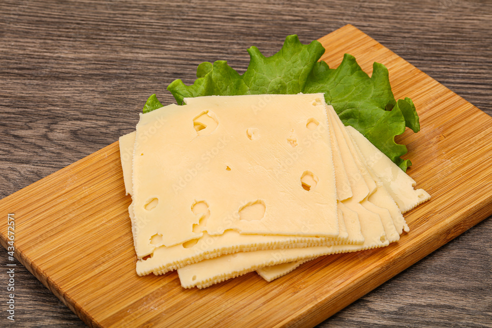 Sliced yellow cheese over board Sliced yellow cheese over board