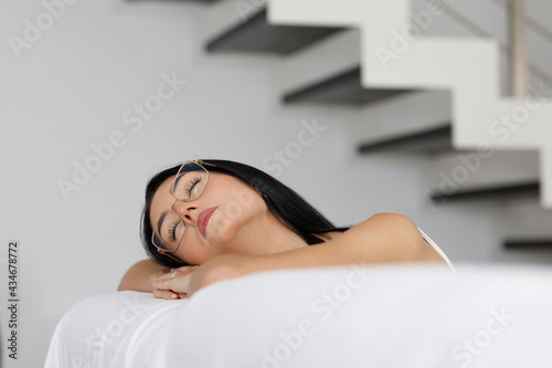 Attractive dark haired young woman sleeping on a sofa