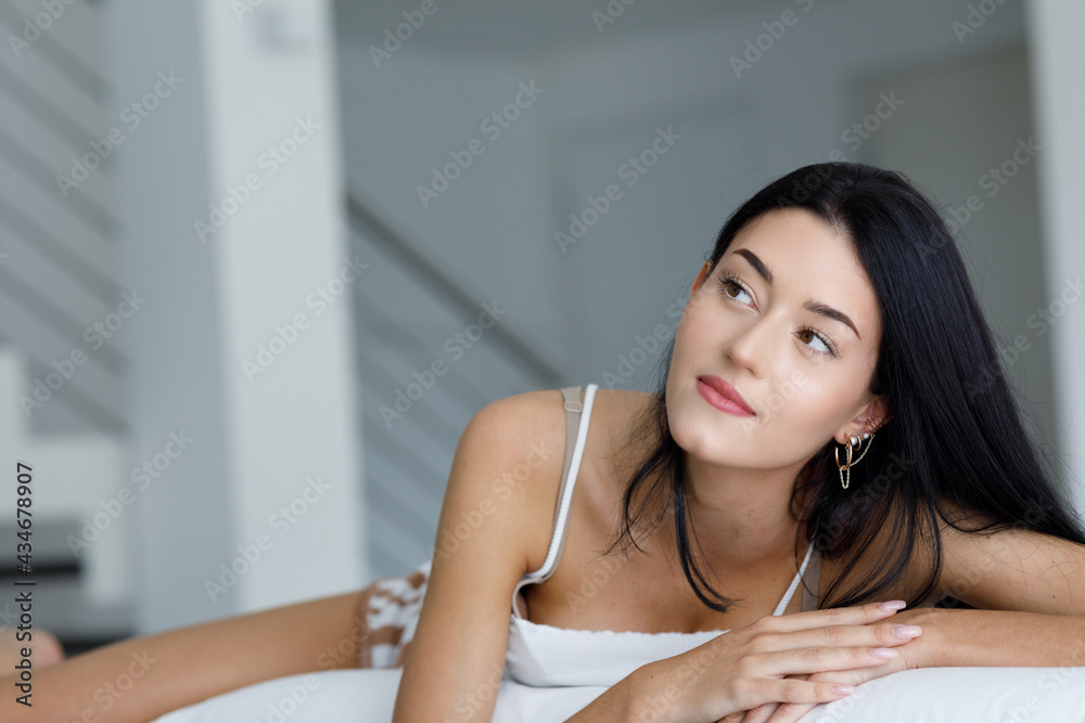 Young woman lying daydreaming or thinking over her aspirations Young woman lying daydreaming or thinking over her aspirations