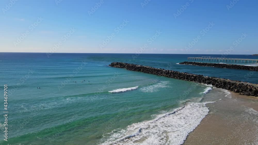People Swim And Surf At Duranbah Beach With Tweed Sand Bypass In Distance In NSW, Australia. - aerial pullback People Swim And Surf At Duranbah Beach With Tweed Sand Bypass In Distance In NSW, Australia. - aerial pullback