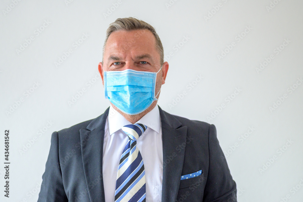 Unshaven businessman wearing a face mask and smart suit and tie Unshaven businessman wearing a face mask and smart suit and tie