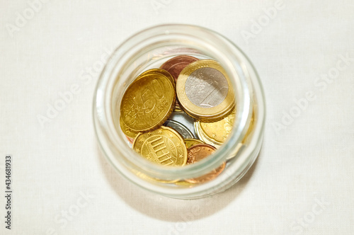 close-up - a glass jar with pennies inside on a white background