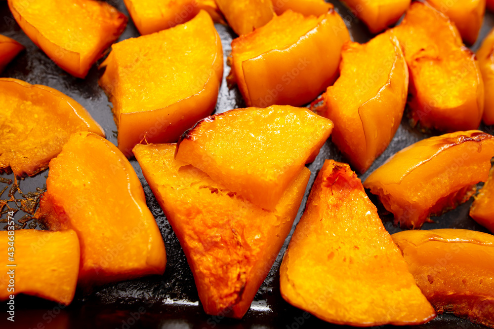 Pieces of pumpkin baked on a baking sheet. Food