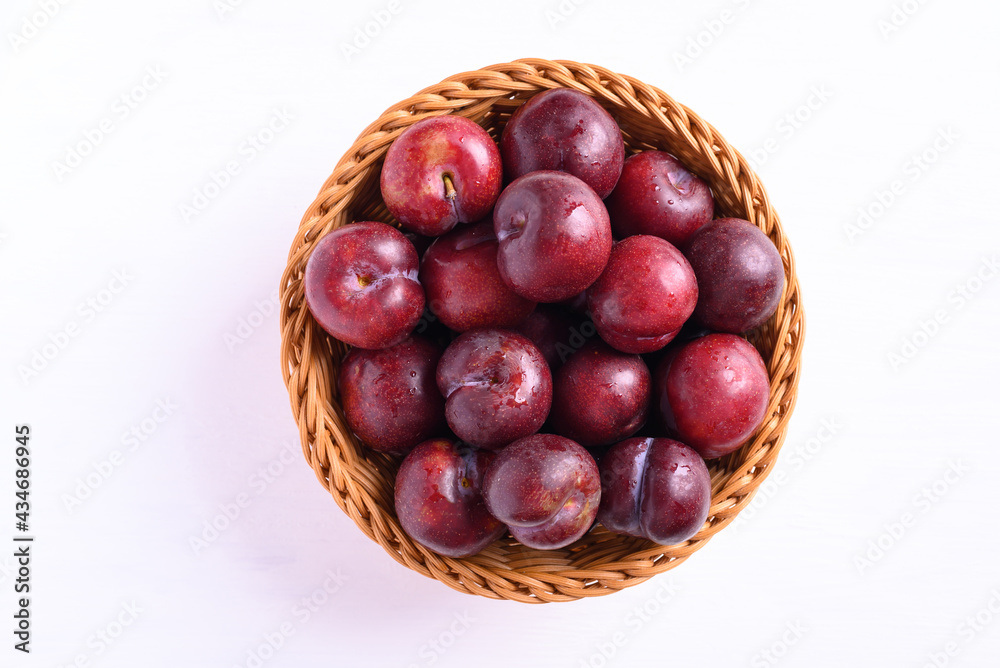 Fresh Japanese or Chinese plum fruit in basket on white background, Top view Fresh Japanese or Chinese plum fruit in basket on white background, Top view