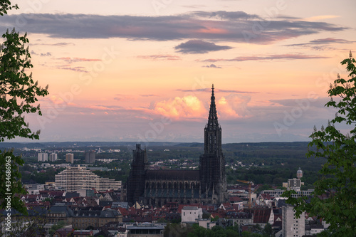 Sunset Panorma Mountain range alps with city ulm and ulmer minster take from a far distance at sunrise sunset dramatic spring sky and blooming tree