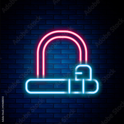 Glowing neon line Bicycle lock U shaped industrial icon isolated on brick wall background. Colorful outline concept. Vector