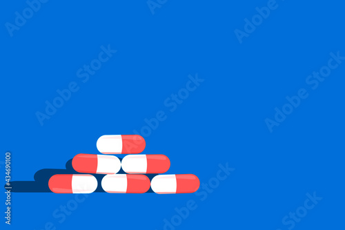 A pile of pills lie on a blue background