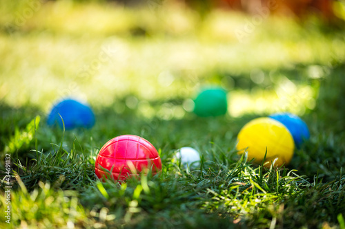 colorful plastic boules or boccia balls are lying on a green meadow photo