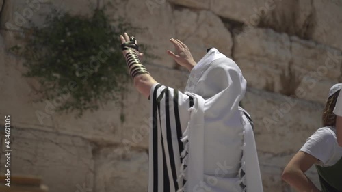 Jewish man pray alone at the wailing wall, Cotel. Strength his believe and faith to god wearing a Tallit and Tefillin. Spirituality act at the sacred holy place in Jerusalem Israel.