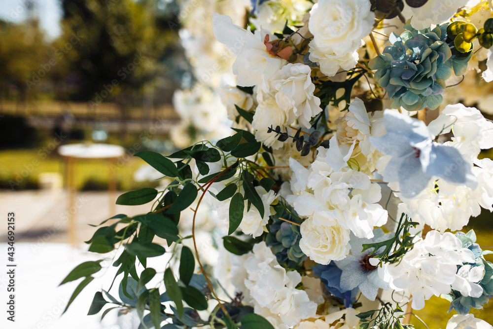 Bouquet of roses on a sunny day background, holiday gift, closeup. Decorative flowers on the wedding arch. Ceremonial decoration on the wedding day. Bouquet of roses on a sunny day background, holiday gift, closeup. Decorative flowers on the wedding arch. Ceremonial decoration on the wedding day.