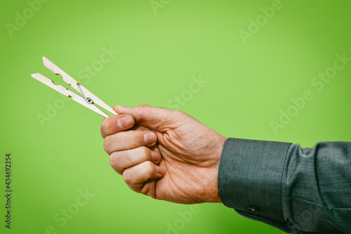 Männerhand hält Wäscheklammer