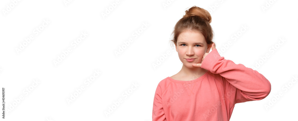 teen girl imitates telephone conversation, keeps hand near ear as if holding mobile phone, saying call me. Place for ad teen girl imitates telephone conversation, keeps hand near ear as if holding mobile phone, saying call me. Place for ad