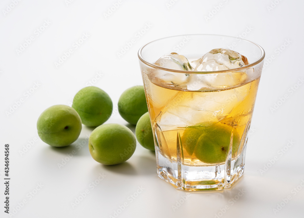 Plum wine and unripe plums on a white background. Plum wine and unripe plums on a white background.