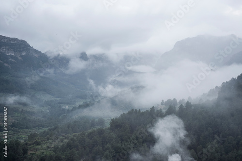 Scenic view of mountain against dramatic sky during foggy weather