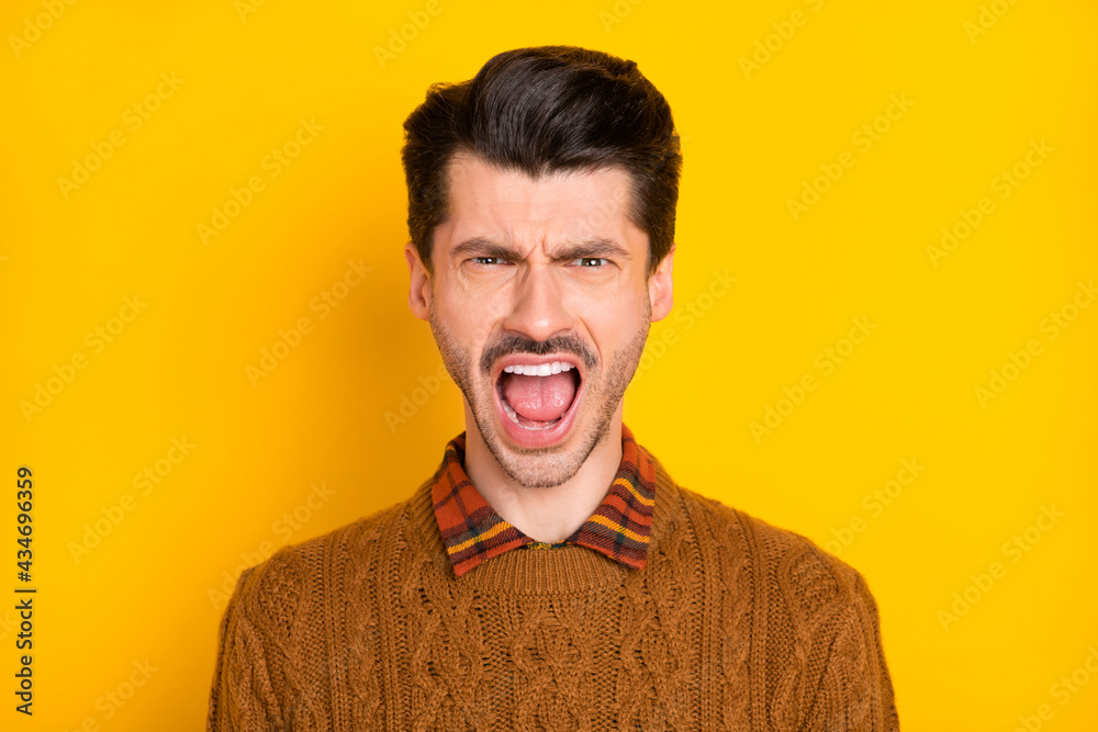 Portrait of unsatisfied handsome guy open mouth yell wear knitter pullover isolated on yellow color background