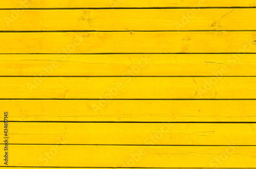 Surface of wooden boards painted with yellow paint. Yellow wood wall background.