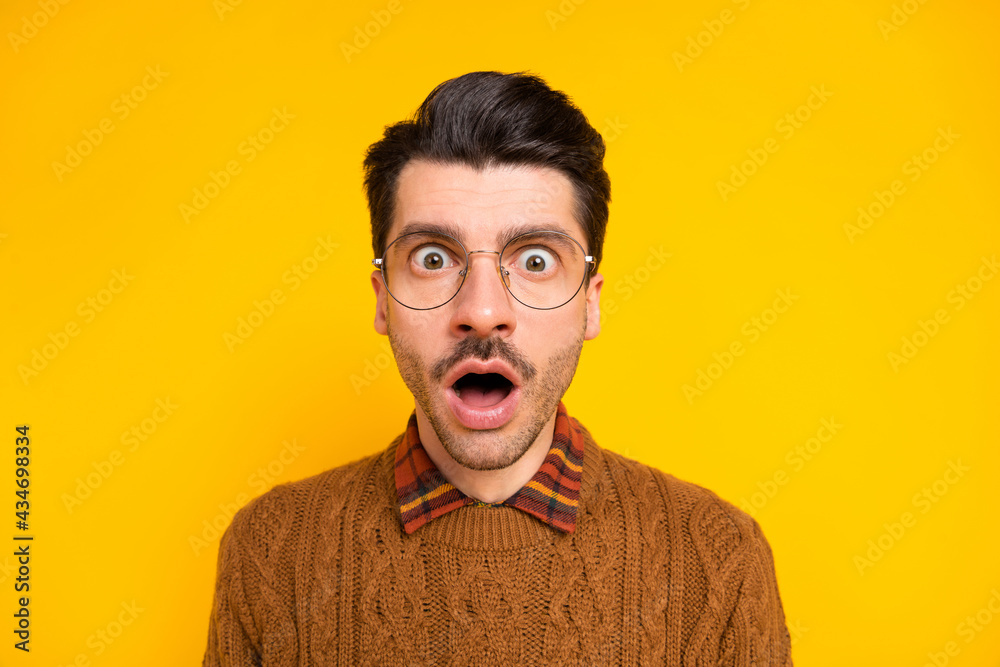 Photo of crazy shocked young guy open mouth staring camera wear brown pullover isolated bright yellow background