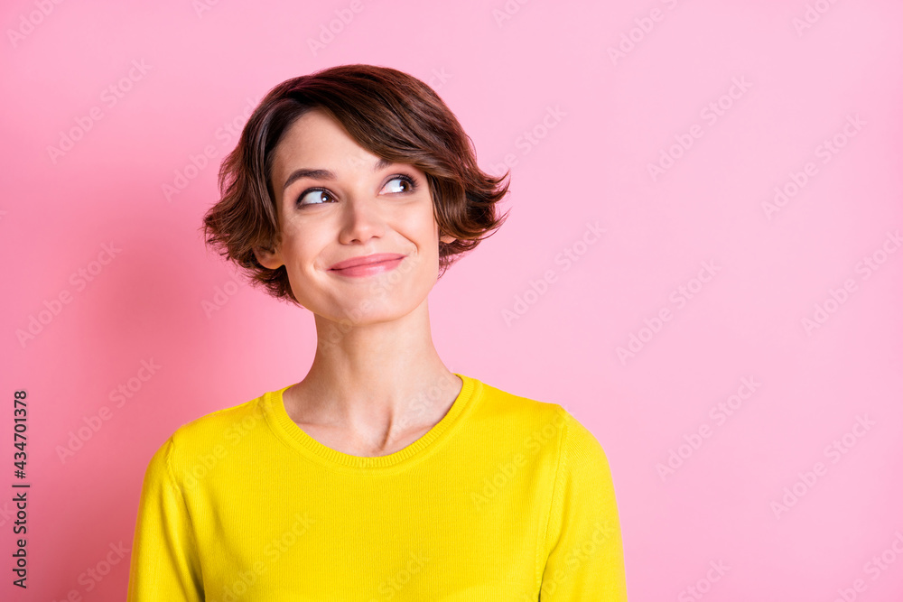 Photo portrait of curious smiling girl bob hairstyle looking empty space isolated on pastel pink color background Photo portrait of curious smiling girl bob hairstyle looking empty space isolated on pastel pink color background