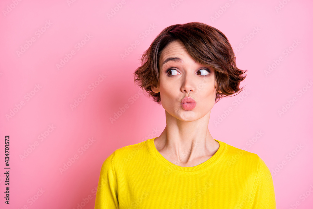 Photo portrait of curious girl looking empty space with pouted lips isolated on pastel pink color background Photo portrait of curious girl looking empty space with pouted lips isolated on pastel pink color background