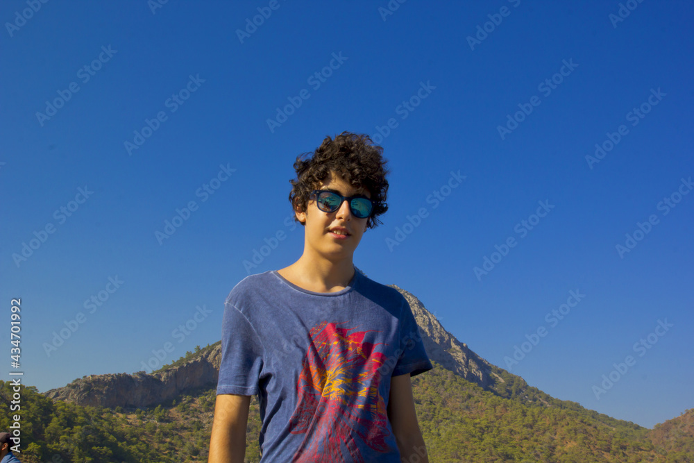 happy young boy in a sunglasses smiling at camera