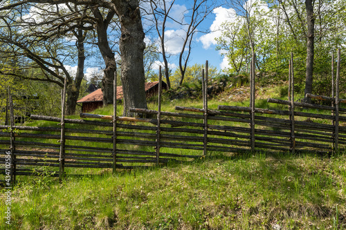 Old traditional swedish wooden fence. Vintage style hedge. Countryside farm authentic cozy hand made wooden fence palisade in a rural area. Scandinavian rural houses interior details.