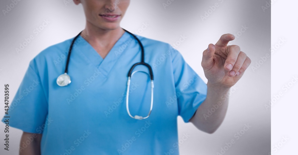 Mid section of female health worker touching invisible screen against grey background Mid section of female health worker touching invisible screen against grey background