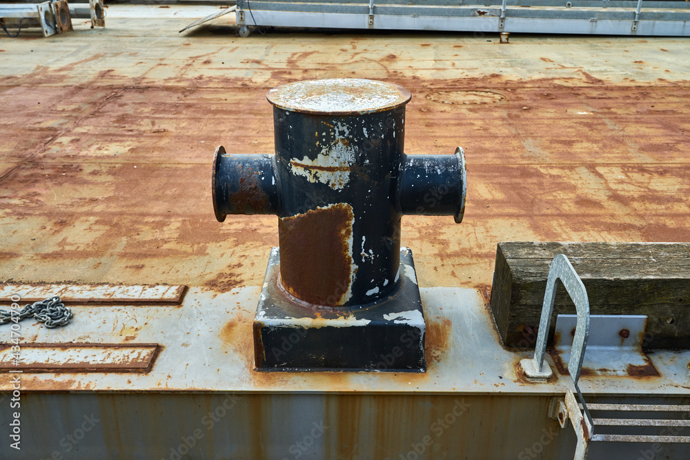 A cruciform mooring bollard showing signs of wear from rope and chains A cruciform mooring bollard showing signs of wear from rope and chains